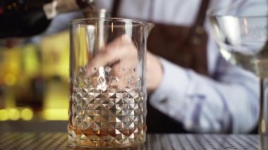 Barmen bar tezgahında müşteriye bir kokteyl hazırlar.