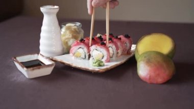 Kil tabakta ton balığı ve mangolu suşi sosu ve mango diliminin yanında.