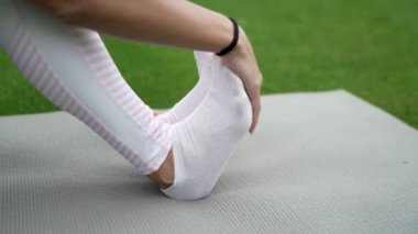 Koşmadan önce ayaklarını esneten bir kızın yakın çekimi, sağlıklı bir yaşam tarzı.