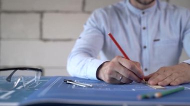 İnşaat mühendisi bina düzenini kontrol ediyor. Mühendis planlara bakıyor.