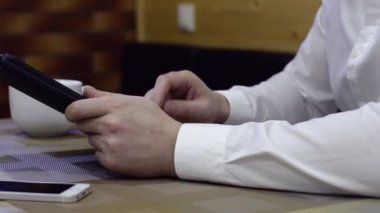 Tablet kahve dükkanında kullanan adam