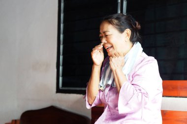 İçerde oturan neşeli orta yaşlı bir kadın, rahat, neşeli bir yüz ifadesiyle gülümseyip yüzüne dokunuyor, boynuna yumuşak bir havlu sarıp sıcaklığı ve günlük mutluluğu yakalıyor..                               