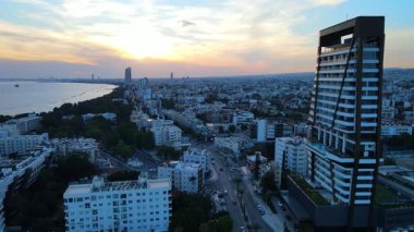 Kıbrıs Rum Kesimi 'nin Limasol kentinin hava manzarası. Akdeniz 'de akşamları yüksek binaları ve otelleri olan bir iş şehri seti. Yüksek kalite 4k görüntü.