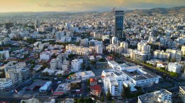 Kıbrıs Rum Kesimi 'nin Limasol kentinin hava panoramik manzarası, modern ufuk çizgisi, yerleşim alanları ve yeşil alanları vurguluyor. Görüntü canlı şehir yaşamını, kentsel gelişimi ve Akdeniz kıyı atmosferini yansıtıyor..