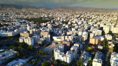 Kıbrıs Rum Kesimi 'nin Limasol kentinin hava panoramik manzarası, modern ufuk çizgisi, yerleşim alanları ve yeşil alanları vurguluyor. Görüntü canlı şehir yaşamını, kentsel gelişimi ve Akdeniz kıyı atmosferini yansıtıyor..