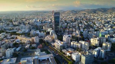 Kıbrıs Rum Kesimi 'nin Limasol kentinin hava panoramik manzarası, modern ufuk çizgisi, yerleşim alanları ve yeşil alanları vurguluyor. Görüntü canlı şehir yaşamını, kentsel gelişimi ve Akdeniz kıyı atmosferini yansıtıyor..