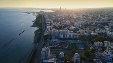 Kıbrıs Rum Kesimi 'nin Limasol kentinin hava panoramik manzarası, modern ufuk çizgisi, yerleşim alanları ve yeşil alanları vurguluyor. Görüntü canlı şehir yaşamını, kentsel gelişimi ve Akdeniz kıyı atmosferini yansıtıyor..