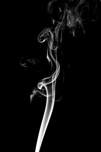 White smoke on black background from the incense sticks