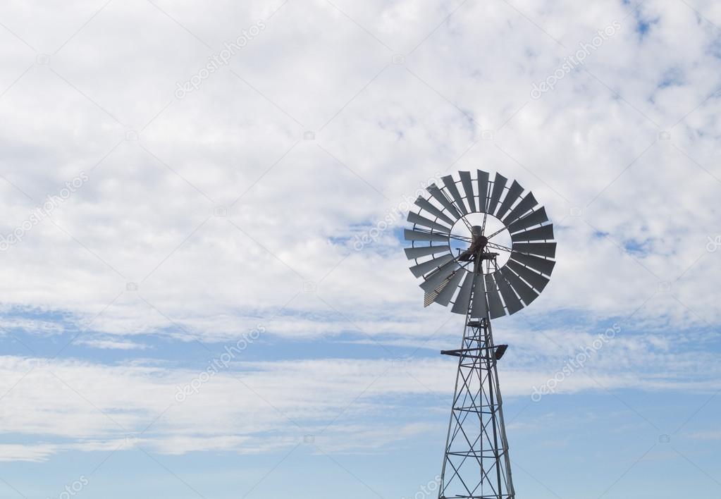 Old west style farm windmill with spinning blades