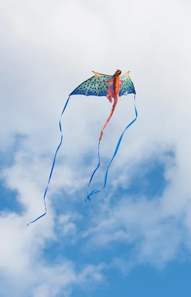 Mythical dragon kite flying in a cloudy sky on a bright sunny day — Stock Photo, Image