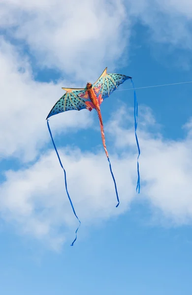 Mythical dragon kite flying in a cloudy sky on a bright sunny day — Stock Photo, Image