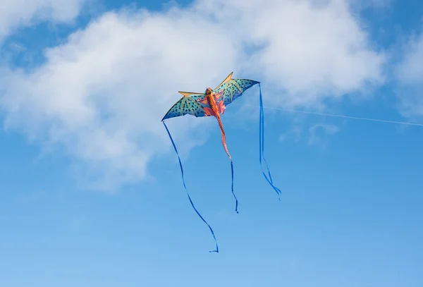 Mythical dragon kite flying in a cloudy sky on a bright sunny day — Stock Photo, Image