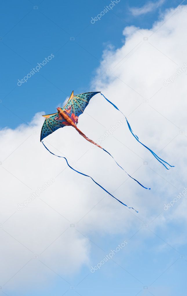 Mythical dragon kite flying in a cloudy sky on a bright sunny day