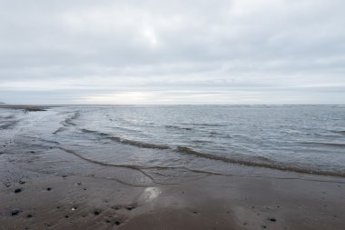 kasvetli bir bulutlu gün bir plaj akan rahatlatıcı ve yumuşak yatıştırıcı dalgalar