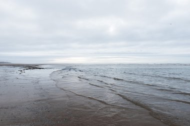 kasvetli bir bulutlu gün bir plaj akan rahatlatıcı ve yumuşak yatıştırıcı dalgalar