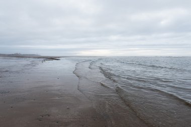 kasvetli bir bulutlu gün bir plaj akan rahatlatıcı ve yumuşak yatıştırıcı dalgalar