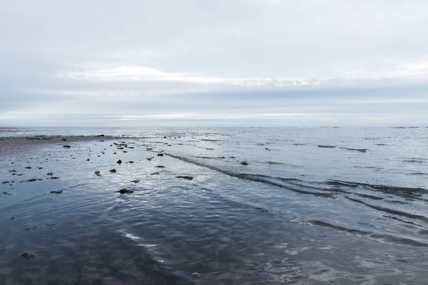 Vagues calmantes relaxantes et douces se jetant dans une plage par temps sombre et couvert — Photo