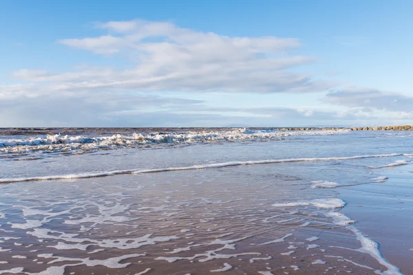 Vagues calmantes et relaxantes se jetant dans une plage au coucher du soleil — Photo