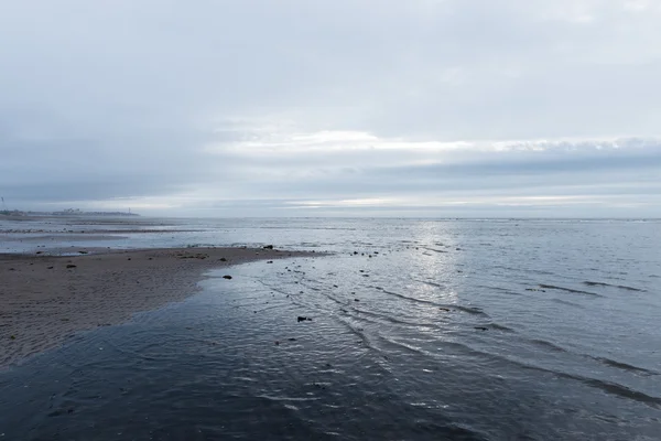 Ontspannen en zachte kalmerende golven stroomt in een strand op een sombere, bewolkte dag — Stockfoto