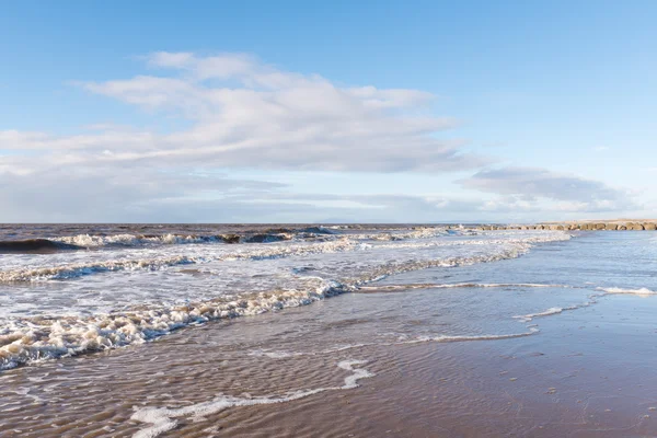 Avkopplande och mild lugnande vågor flyter in i en strand vid solnedgången — Stockfoto