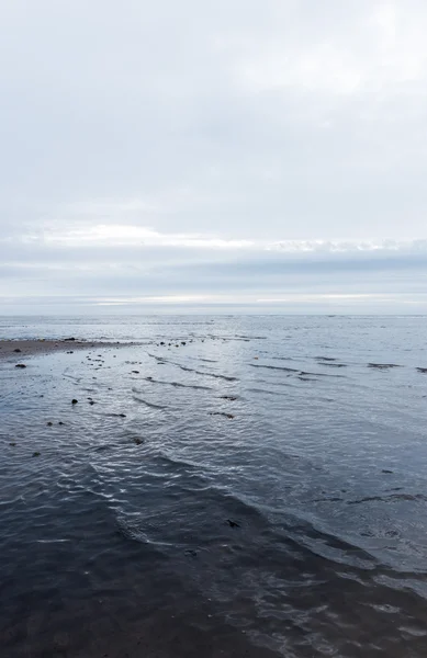 Vagues calmantes relaxantes et douces se jetant dans une plage par temps sombre et couvert — Photo
