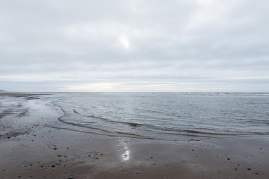kasvetli bir bulutlu gün bir plaj akan rahatlatıcı ve yumuşak yatıştırıcı dalgalar