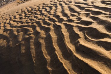 Gün batımında kum sıcak bir altın plajda dalgalanma dokular