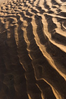 Gün batımında kum sıcak bir altın plajda dalgalanma dokular