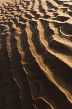 Gün batımında kum sıcak bir altın plajda dalgalanma dokular