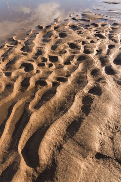 Gün batımında kum sıcak bir altın plajda dalgalanma dokular