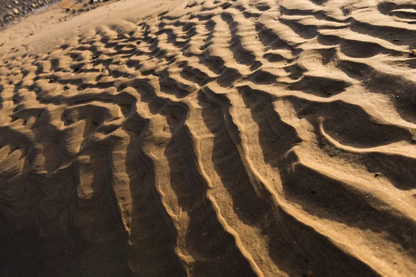 Gün batımında kum sıcak bir altın plajda dalgalanma dokular