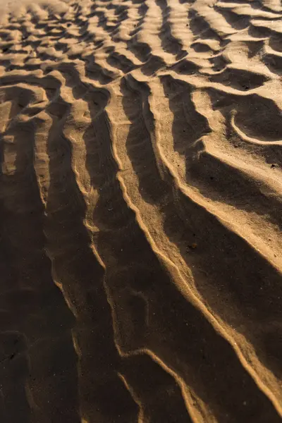 Gün batımında kum sıcak bir altın plajda dalgalanma dokular