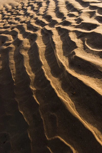 Gün batımında kum sıcak bir altın plajda dalgalanma dokular