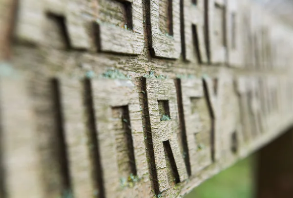 Lettere intagliate a mano su una vecchia panca di legno ricoperta di muschio — Foto Stock