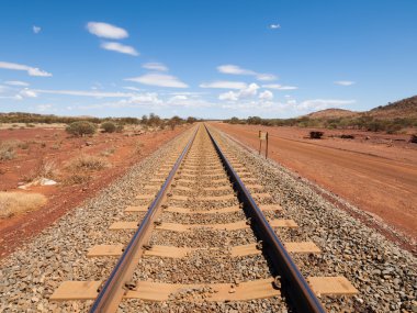 Australia, Northern territory, 05/21/2014, Outback railroad crossing disappearing into the horizon. clipart