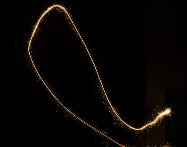 Trilha de luz sparkler em ambiente escuro usando velocidade do obturador lenta — Fotografia de Stock