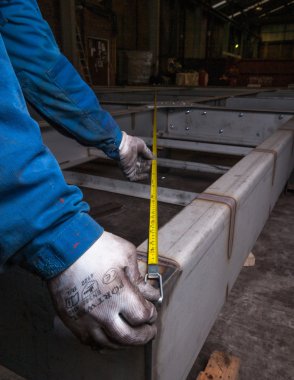 bir endüstriyel fabrika ayarı bir mezura ile mesafe ölçme