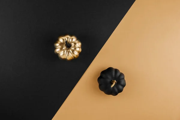 Seasonal fall sale, Black Friday. Discount minimal concept. Autumn composition with golden and black decorative pumpkins on nude background. Flat lay, top view, copy space.