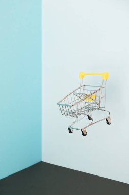 Mavi arka planda alışveriş arabası var. Karantina konseptiyle güvenli online alışveriş. Fotokopi alanı olan boş süpermarket tramvayı