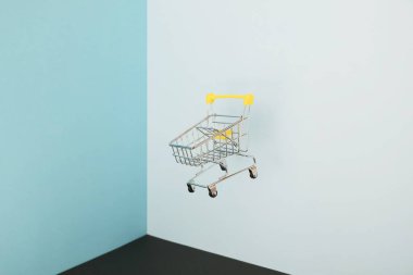 Mavi arka planda alışveriş arabası var. Karantina konseptiyle güvenli online alışveriş. Fotokopi alanı olan boş süpermarket tramvayı