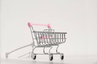 Alışveriş arabası beyaz arka planda izole edilmiş. Karantina konseptiyle güvenli online alışveriş. Kopya alanı olan boş süpermarket alışveriş arabası