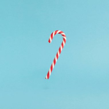 Mavi arka planda kırmızı uçan şeker kamışı. Mutlu Noeller havalanan şekerler ve mutlu yıllar konsepti.