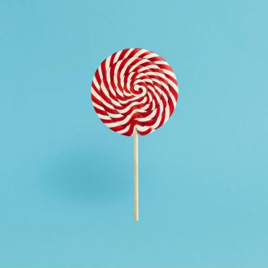 Mavi arka planda renkli lolipop, tahta çubuk, kırmızı ve beyaz spiral, çocukluk tatlısı, Noel konsepti