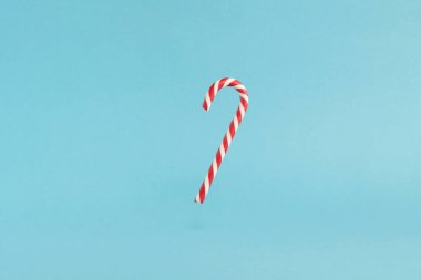 Mavi arka planda kırmızı uçan şeker kamışı. Mutlu Noeller havalanan şekerler ve mutlu yıllar konsepti.