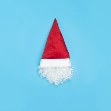 Mavi arka planda şapkalı Noel Baba 'nın başı. Asgari Noel konsepti. Beyaz sakal