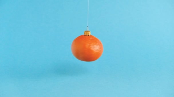 Turuncu mandalina meyvesinden yapılmış dönen Noel oyuncağı. Minimum Yeni Yıl konsepti. Yükselme. — Stok video