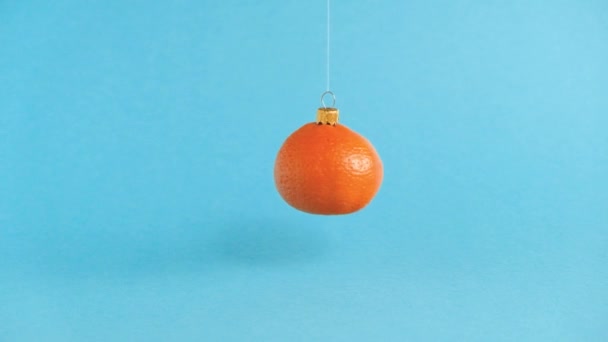 Turuncu mandalina meyvesinden yapılmış dönen Noel oyuncağı. Minimum Yeni Yıl konsepti. Yükselme. — Stok video