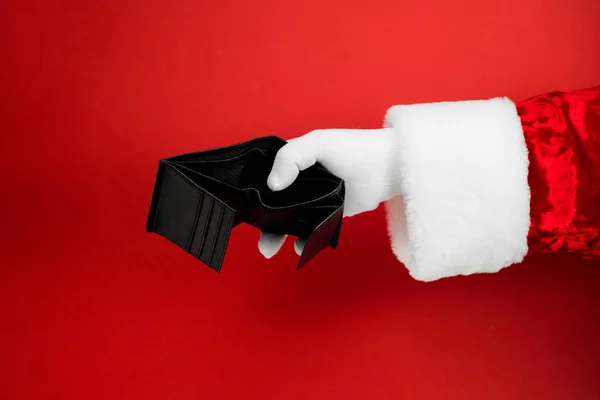 Noel Baba kırmızı arka planda boş bir cüzdan açtı. Emeklilik ve işsizlik kavramında yoksulluk. 