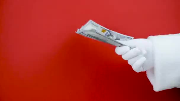 Kerstman hand met geld op rode achtergrond. Hand met cash. — Stockvideo