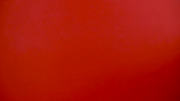 赤い背景にカラフルなロリポップとサンタの手、木の棒、赤と白のスパイラル、子供の頃のお菓子、クリスマスのコンセプト — ストック動画